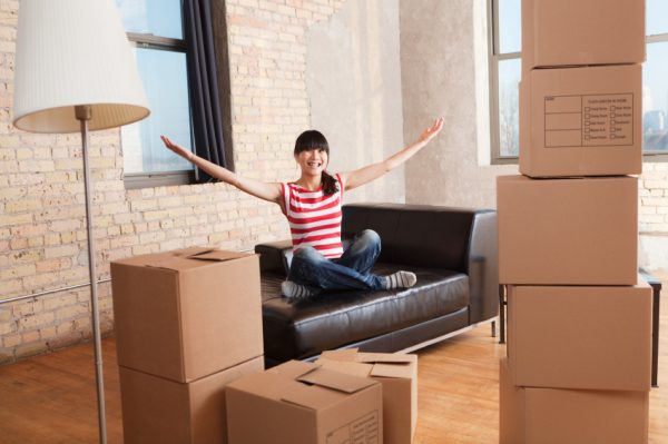 a woman sitting crossed legs on a couch while unpacking