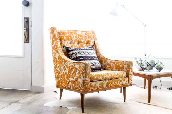 an elegant chair with yellow embroidered covers