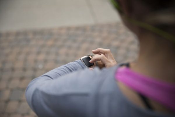 a woman using a smart watch while running