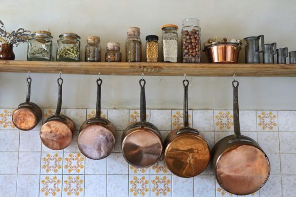 pans and pots hanging on a kitchen shelf