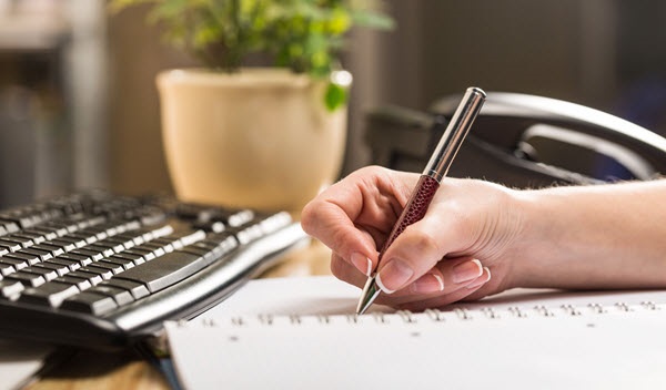 A person writing on a notebook